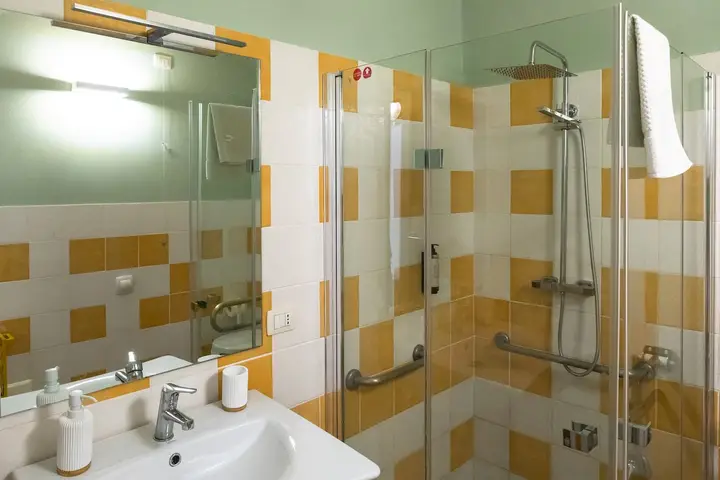 Un bagno con doccia e piastrelle in maiolica