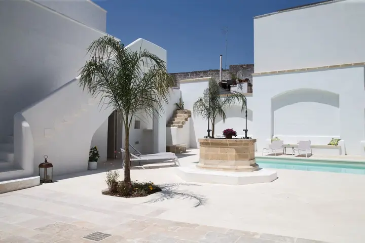 Il cortile della piscina con gli alberi e il pozzo