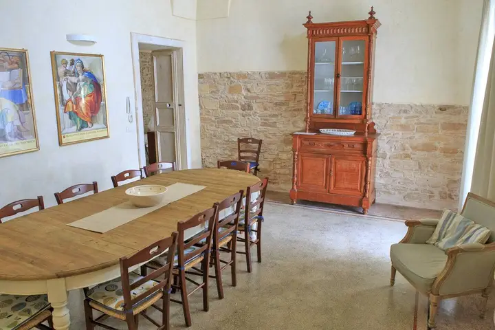 La sala da pranzo con la credenza antica e il muro in pietra