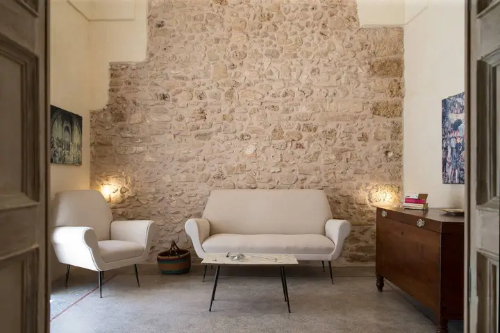 Il salotto con il muro in pietra a vista
